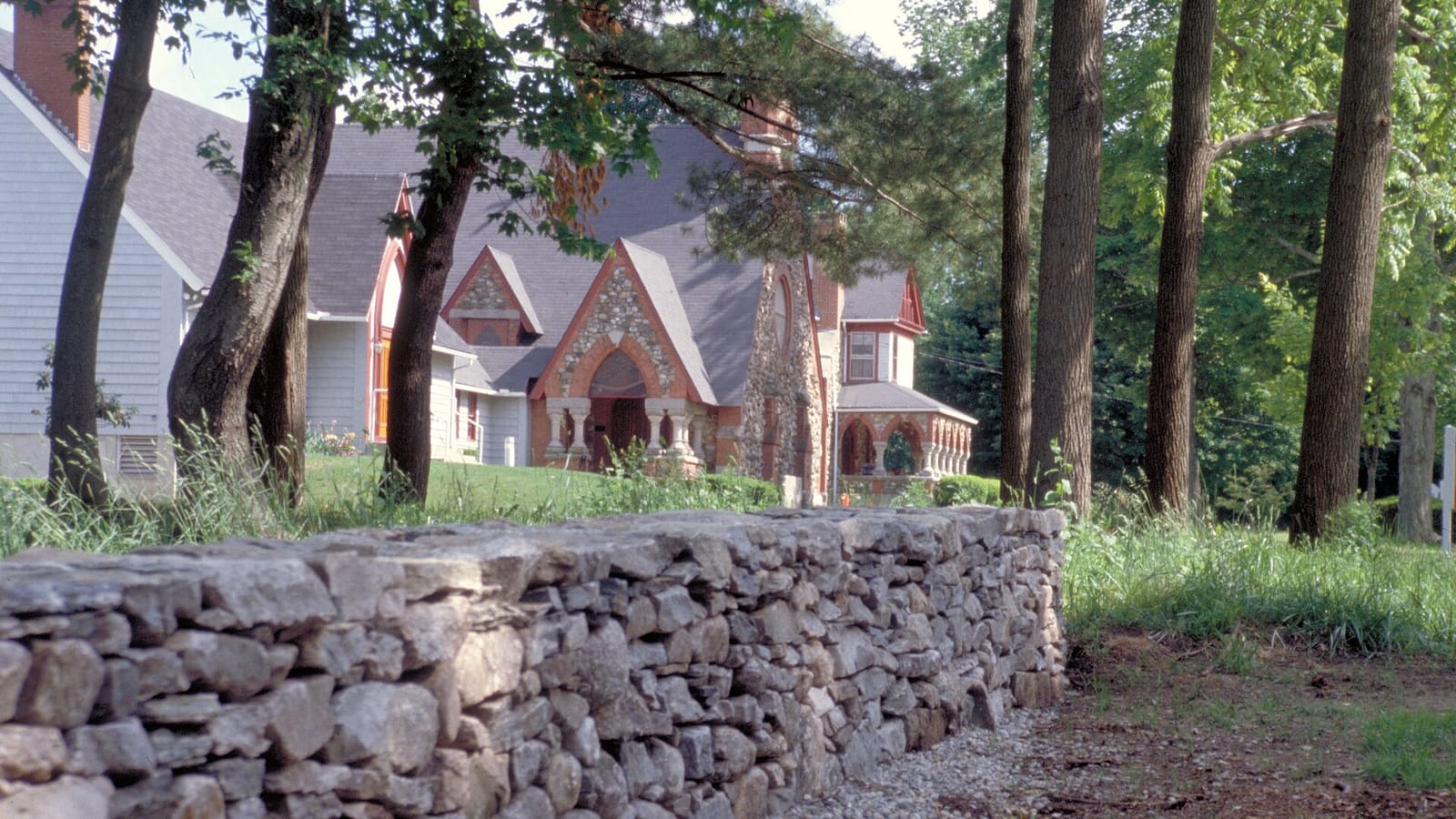 Houses behind a stone wall and tall trees