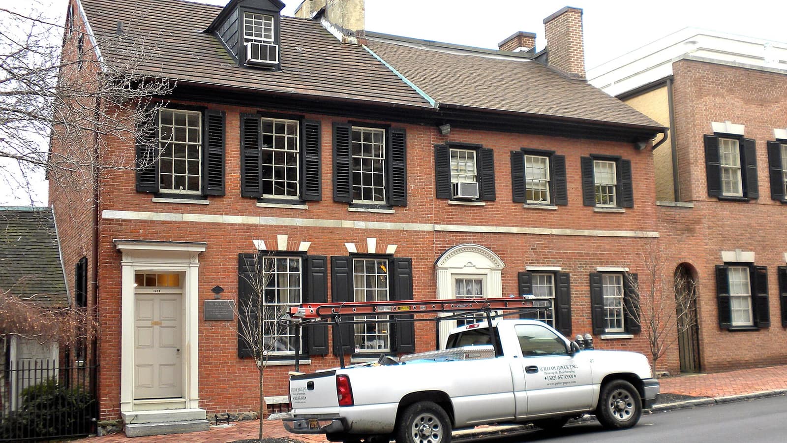 Red brick historic house beside a street