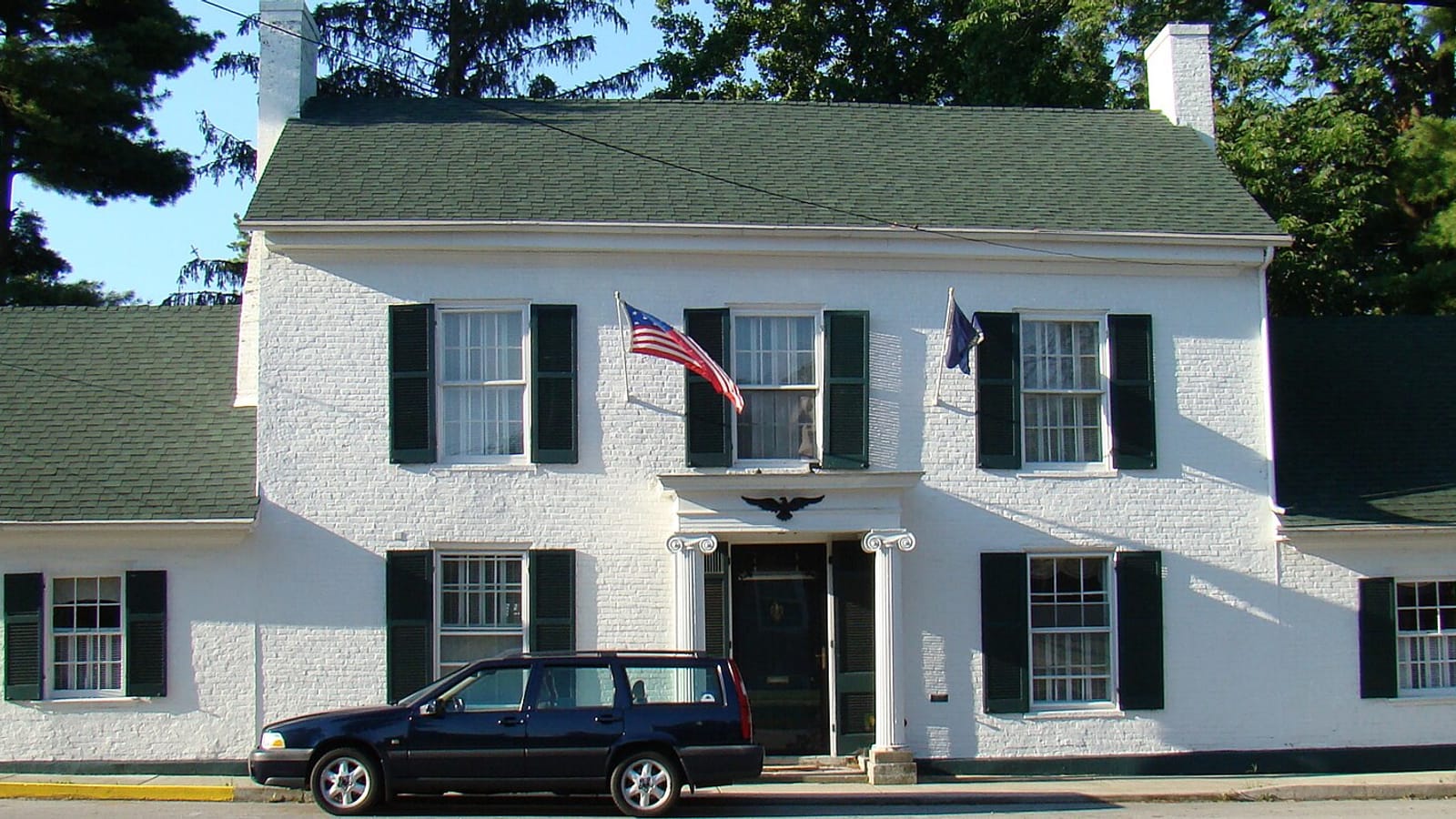 White two-story building with a covered porch