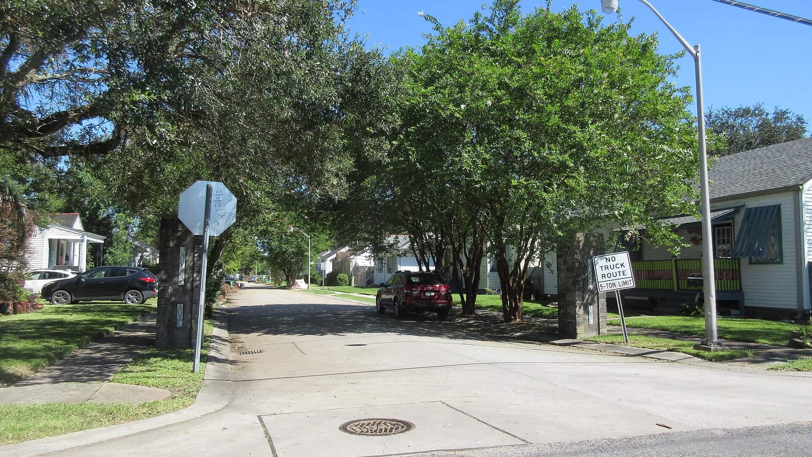 Residential street lined with trees and low houses