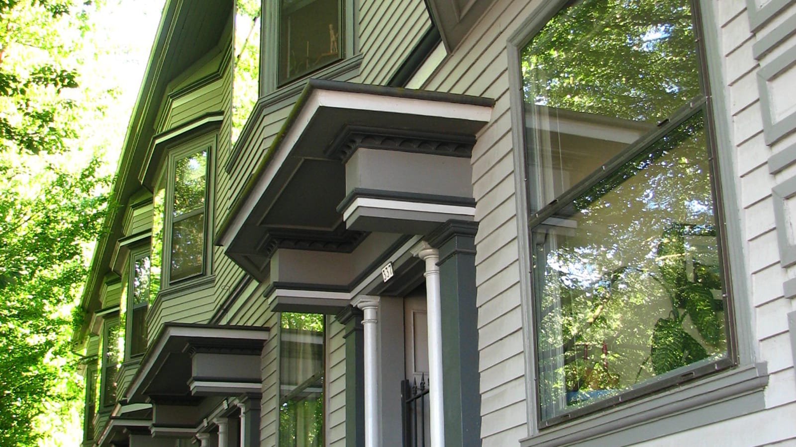 Wood-sided apartment facade with projecting window bays