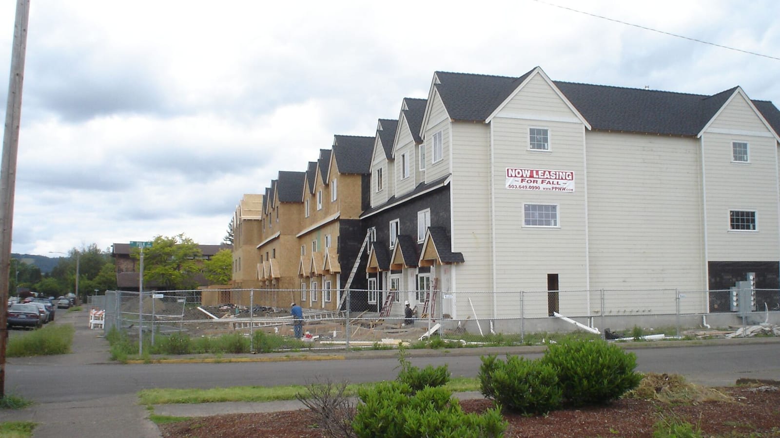Apartment buildings under construction behind temporary fencing