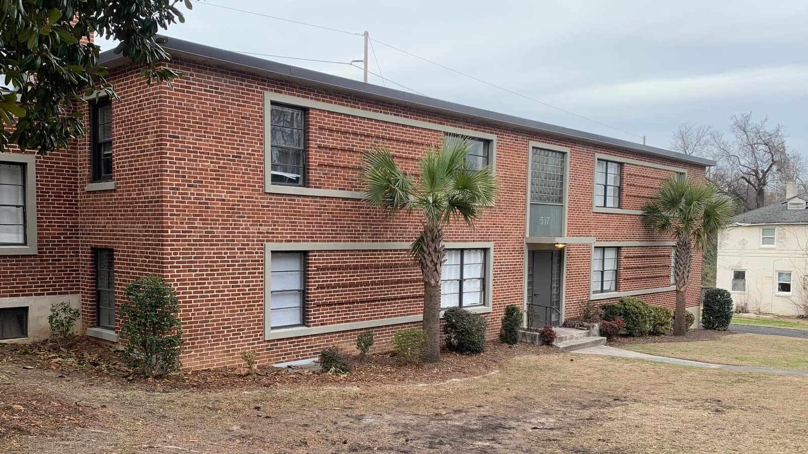 Two-story brick apartments beside a lawn