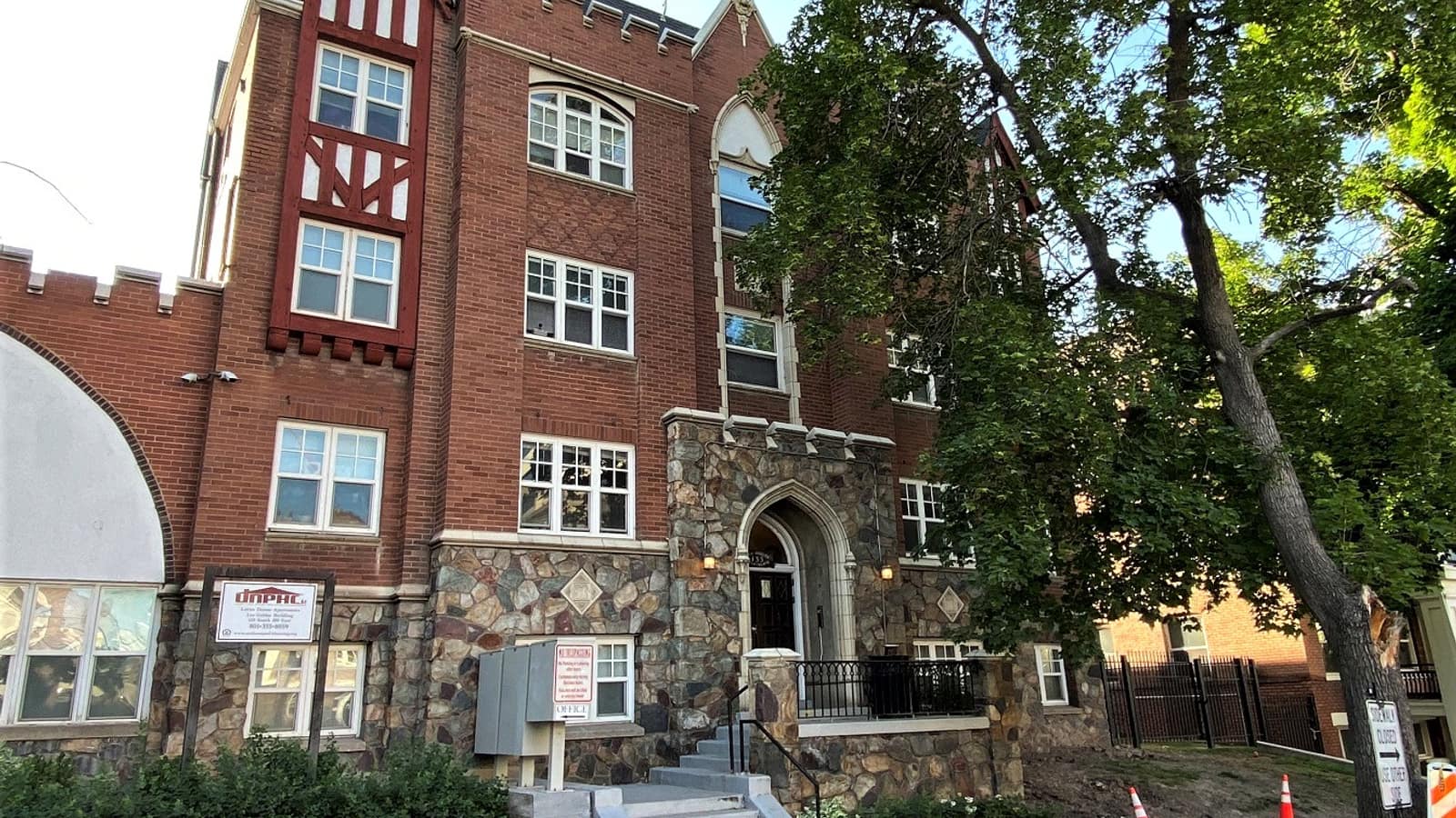 Brick apartment facade with decorative gables and a stone entrance surround