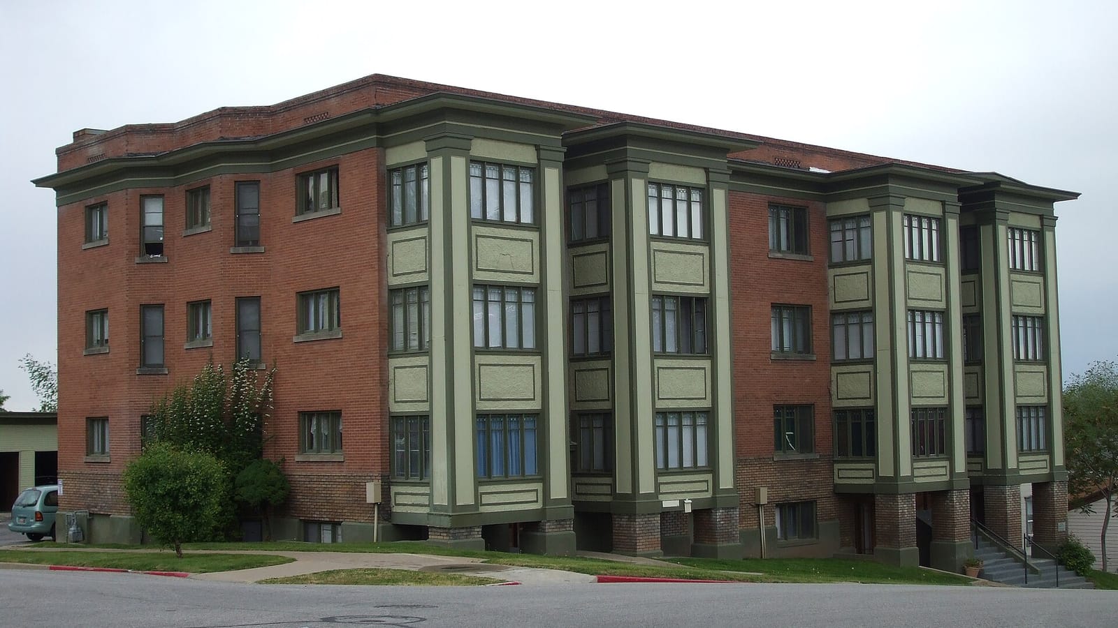 Brick apartment building with green projecting window bays