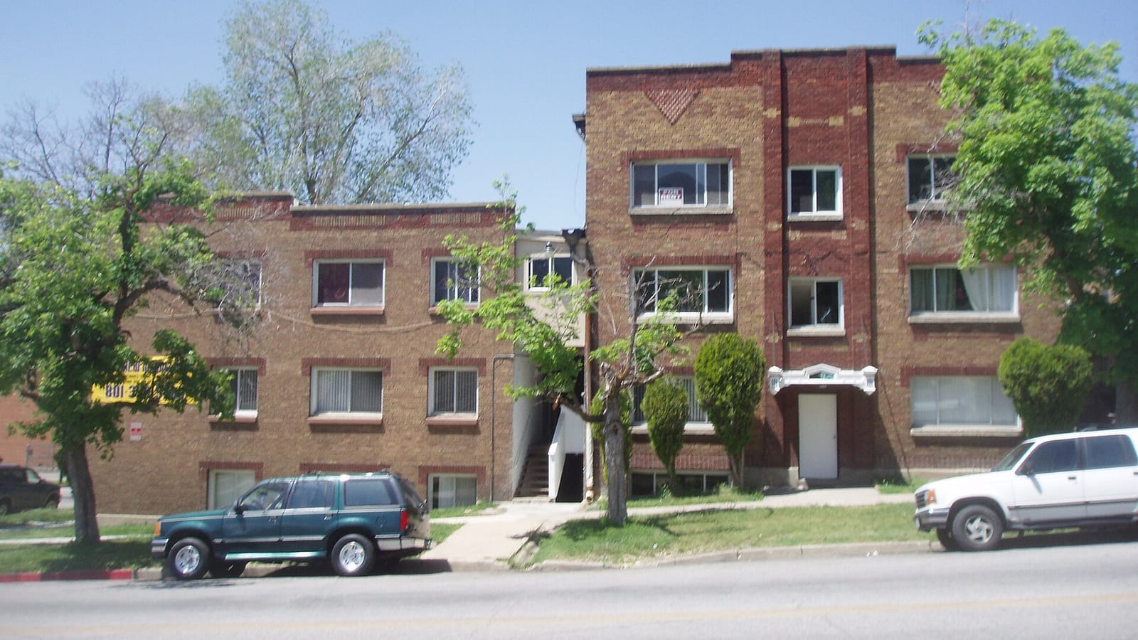 Brick apartment building with two wings and a central entrance