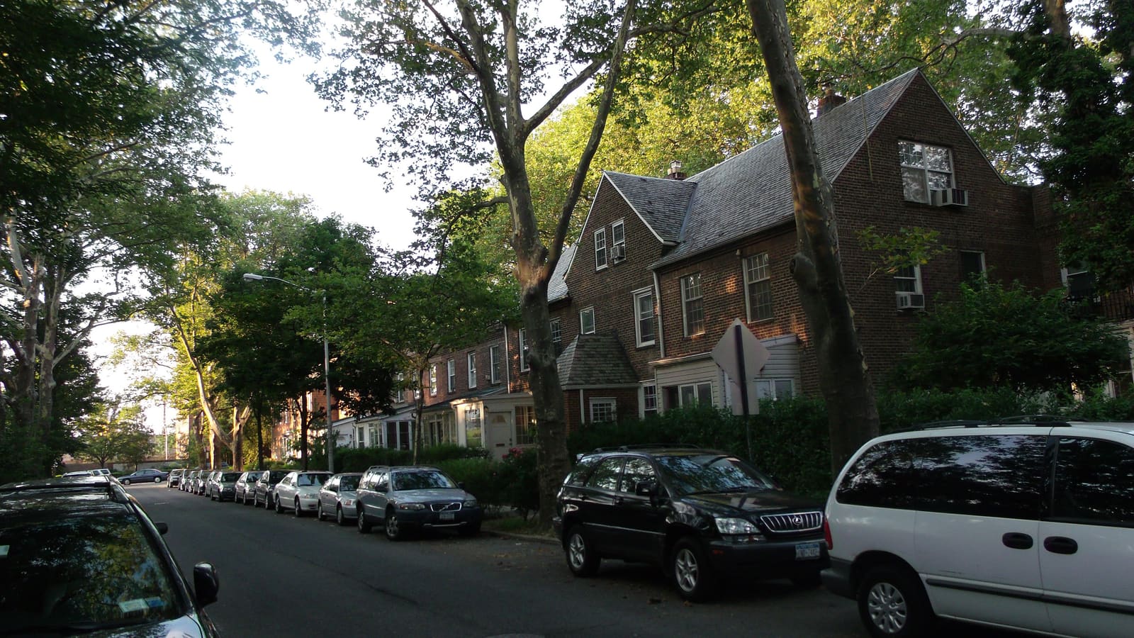 Brick row houses with slate roofs on a quiet tree-lined street