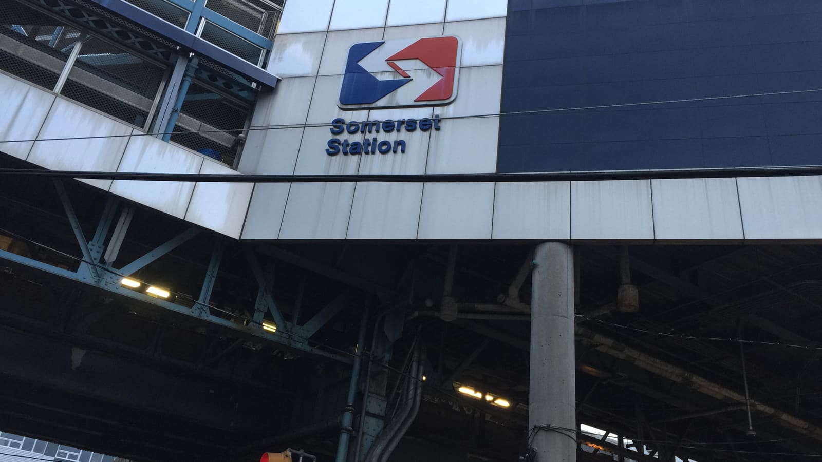 Sign reading Somerset Station with the SEPTA logo on the white panels of an elevated train station, above the steel structure of the elevated line