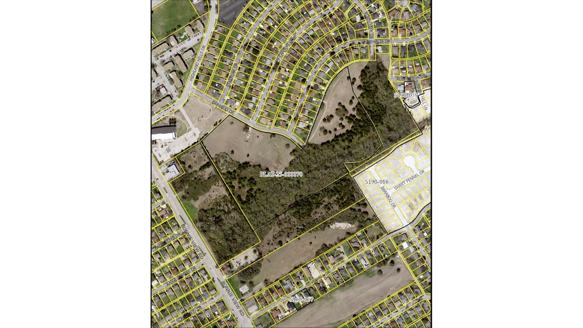Aerial photograph of a wooded tract outlined in yellow between Baraboo Drive and Bonnie View Road, surrounded by streets of single-family houses