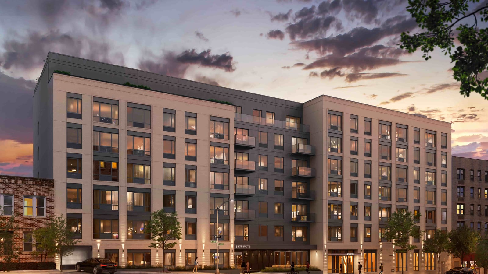Rendering at dusk of a seven-story apartment building with light tan and charcoal panels, floor-to-ceiling windows, two stacks of glass balconies in the dark center section, a setback top floor with plantings, a garage door at the far left, a lit entrance under a dark canopy, street trees and a few people on the sidewalk