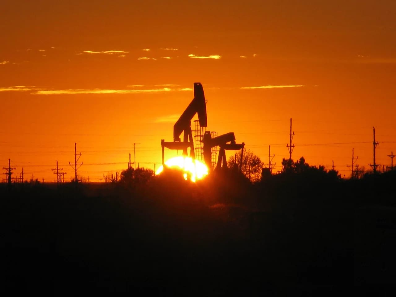 Pump jacks silhouetted against sunset near Midland, Texas