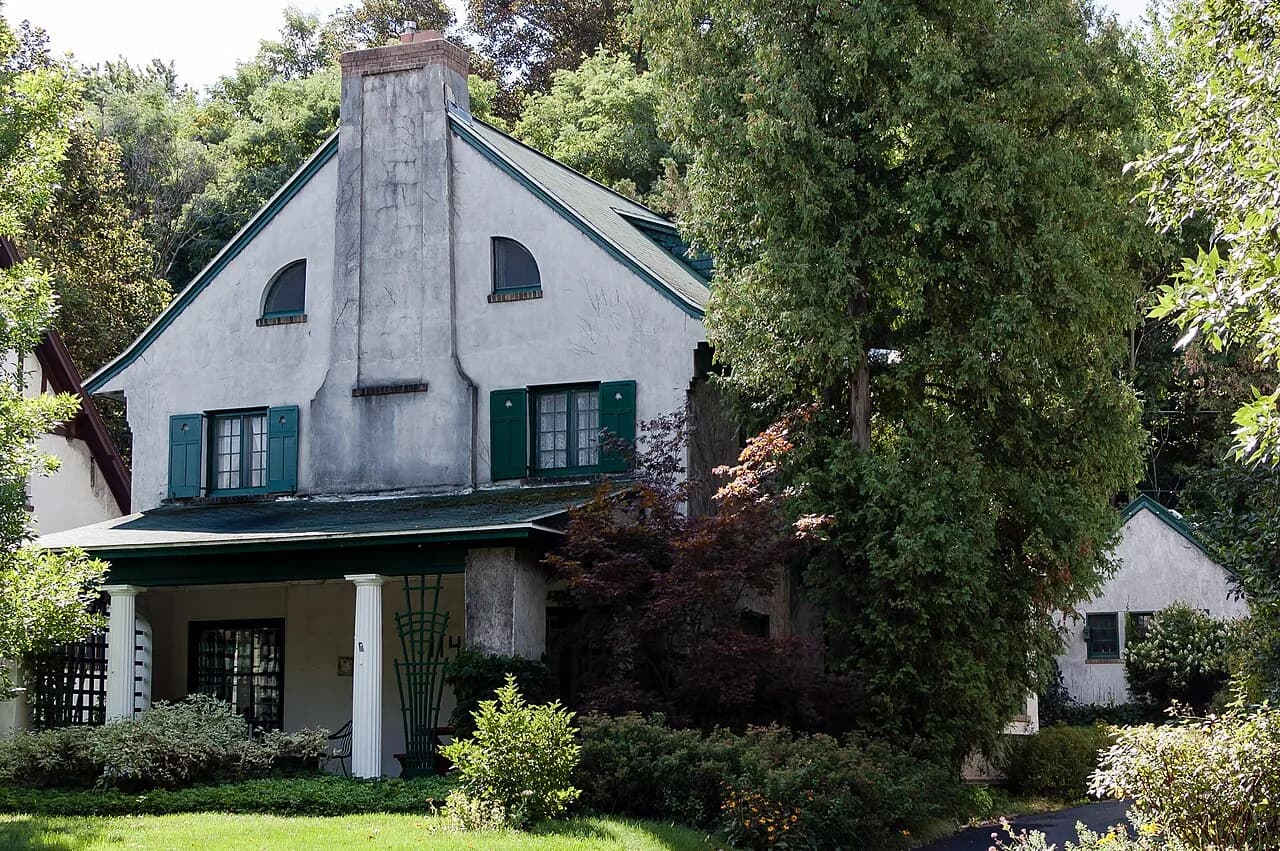 Stucco exterior, porch and mature trees at Spencer House in Syracuse