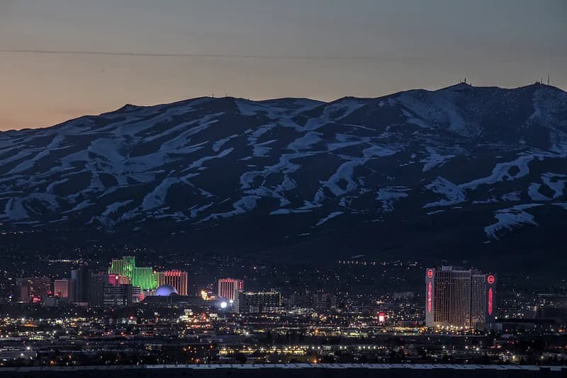 Reno buildings at dusk beneath snow-covered mountains