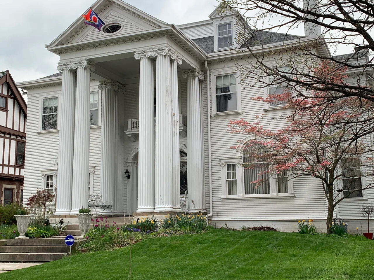White house with tall columns, siding and porches in Toledo’s Old West End
