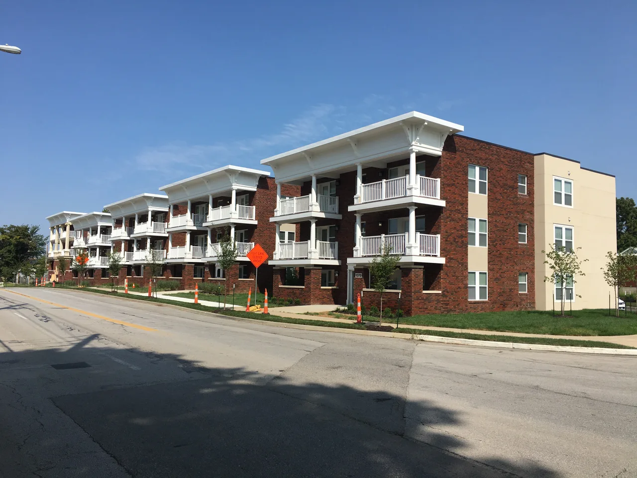 Brick colonnade apartment buildings with stacked white porches on East 27th Street in Kansas City