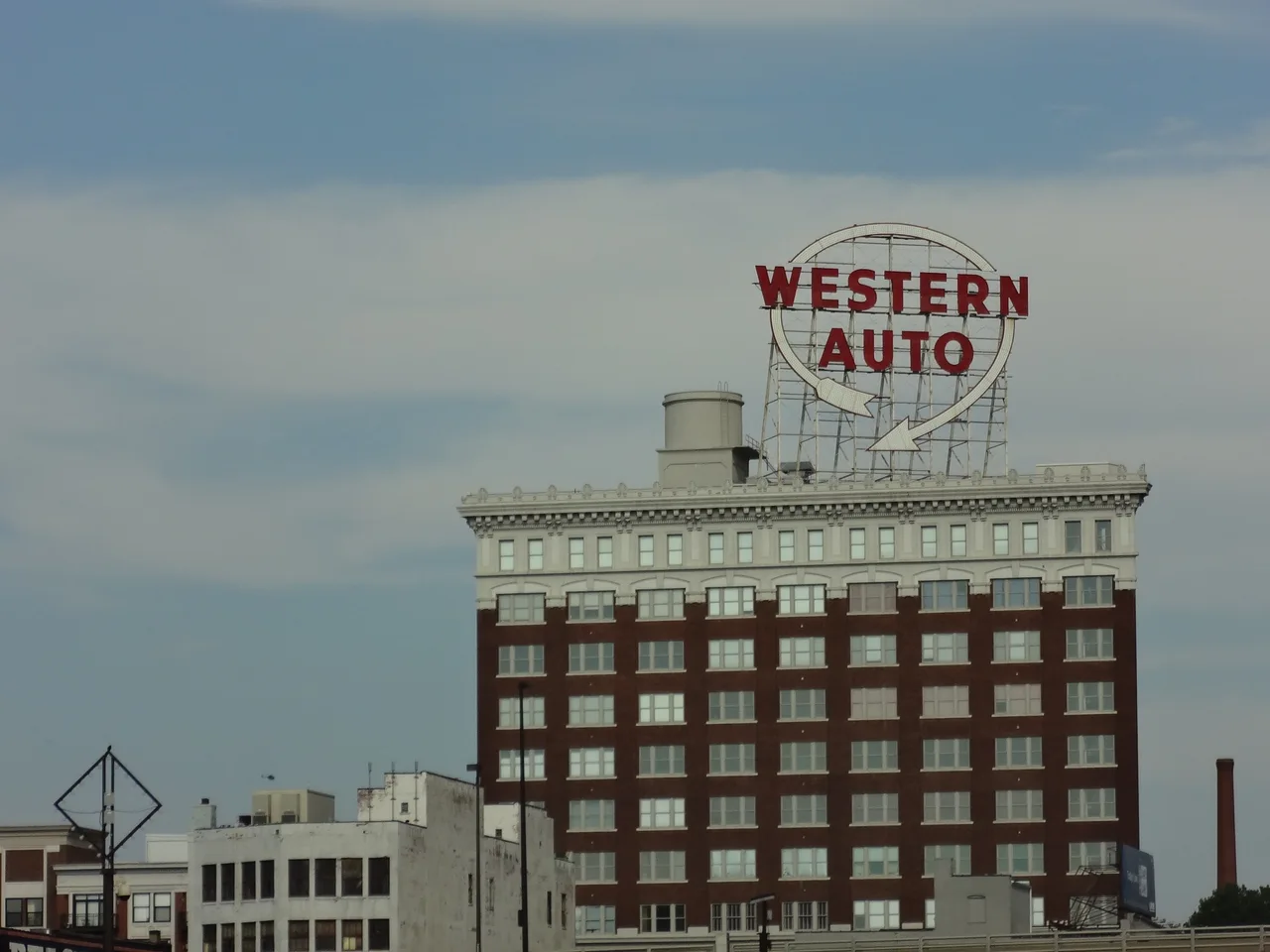 Tall curved brick Western Auto building and rooftop sign seen from the west in Kansas City