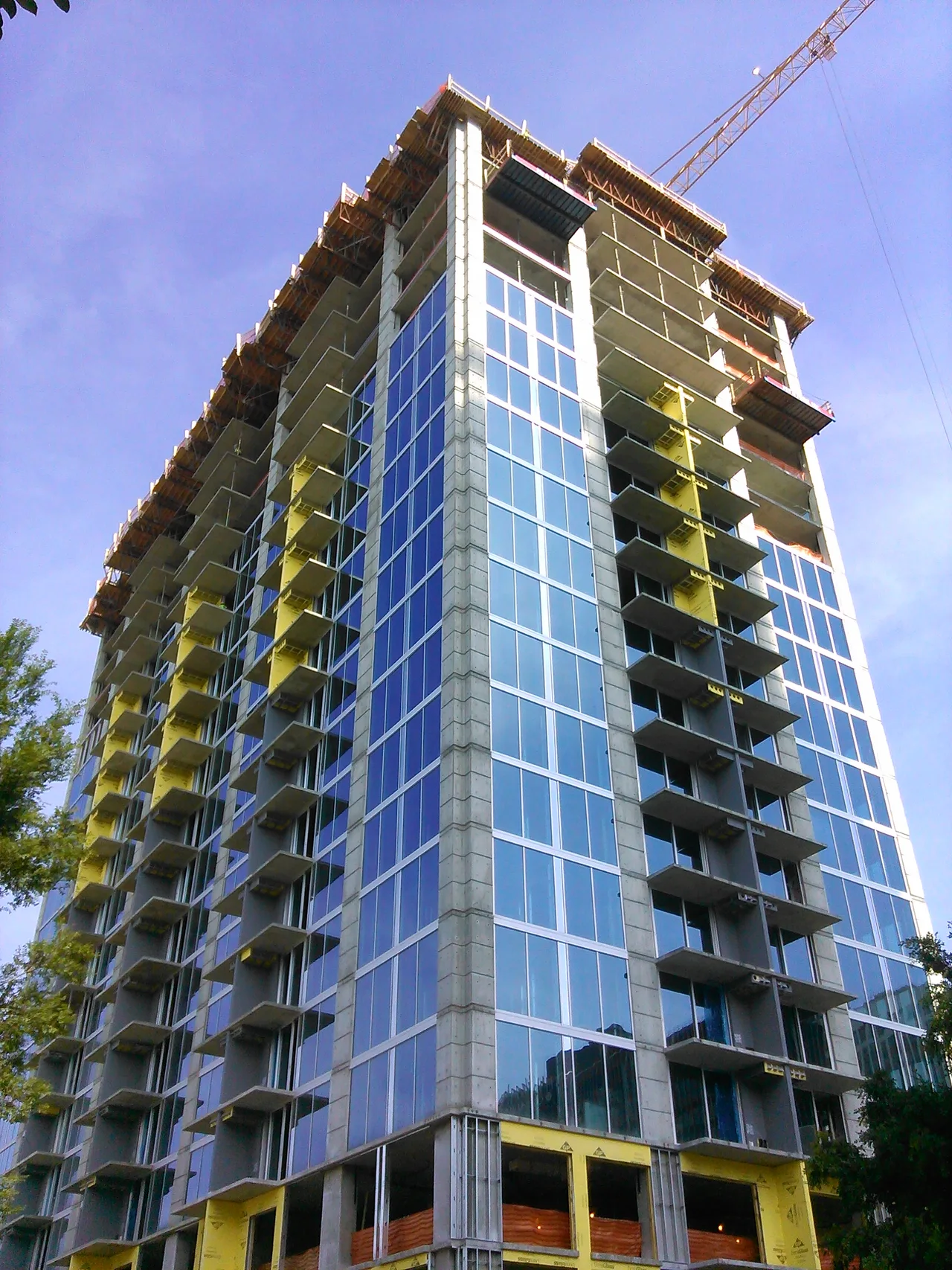 Crane and unfinished balconies at the Skyhouse apartment tower under construction in Raleigh