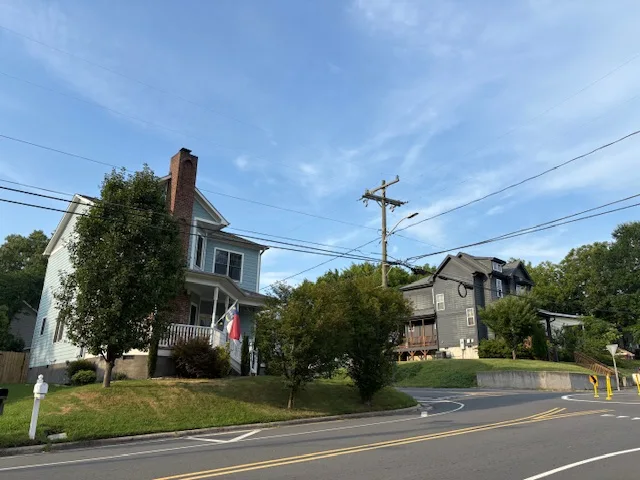 Porch-front houses beside a curved street in Durham’s Southside–Saint Teresa