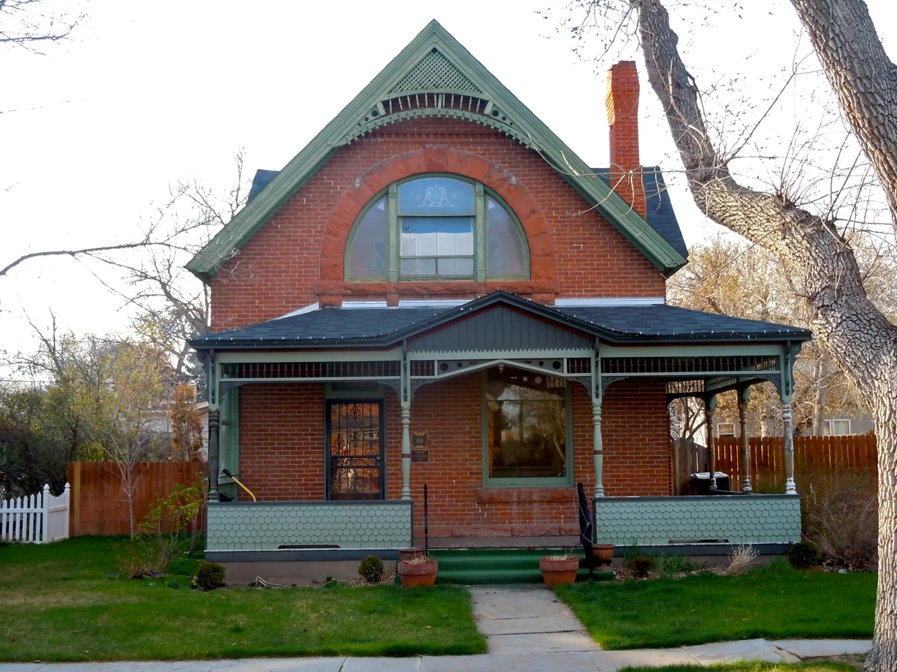 Brick house with a steep green gable and front porch at Keefe Row in Cheyenne