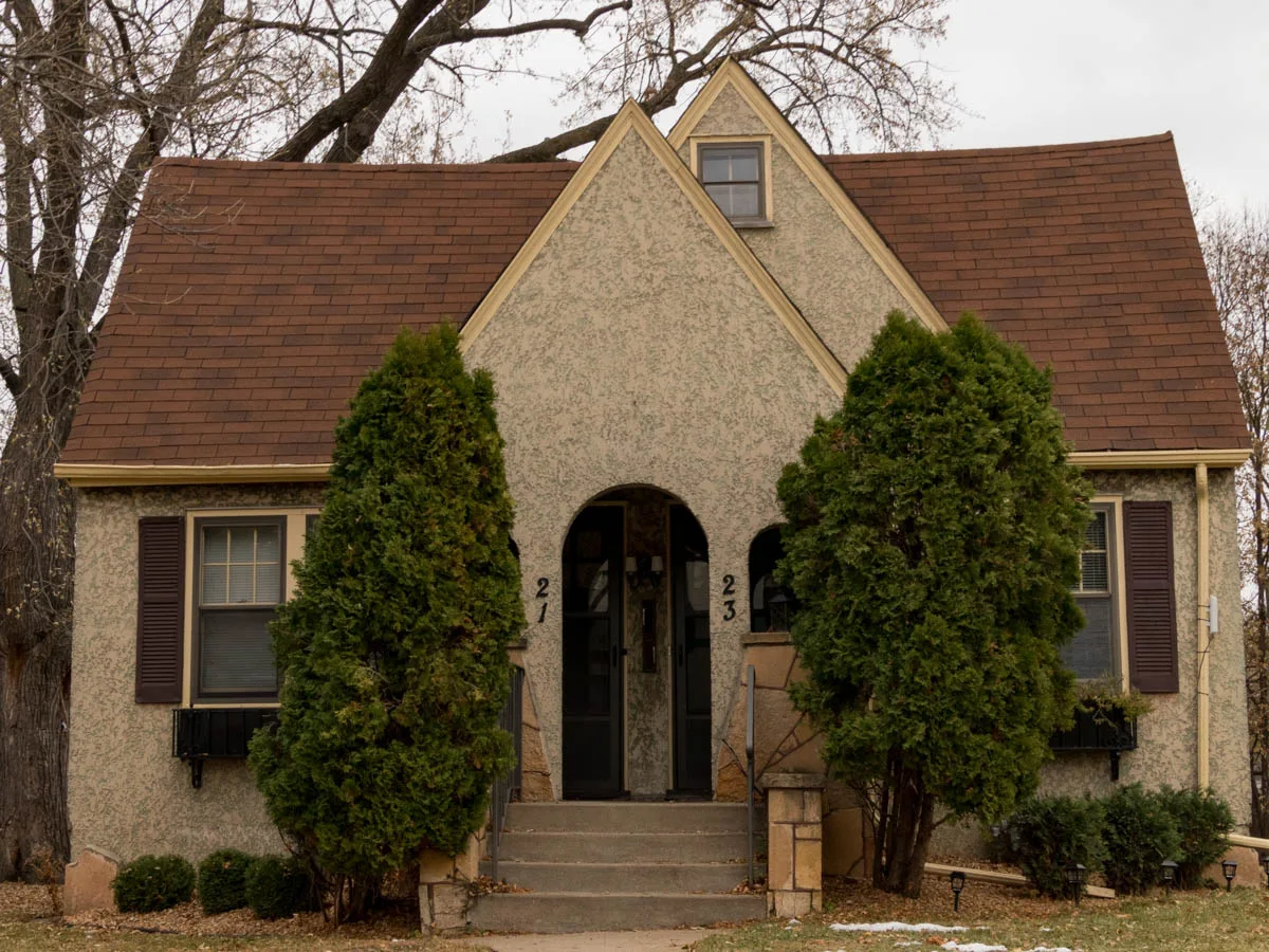 Two arched entrances beneath a broad gabled roof at a Nokomis Knoll building in Minneapolis