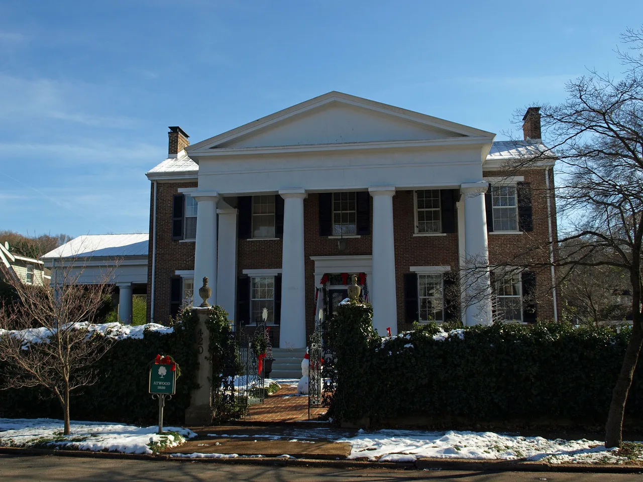 Brick house with broad white columns and a snowy front garden at 420 Randolph Avenue in Huntsville