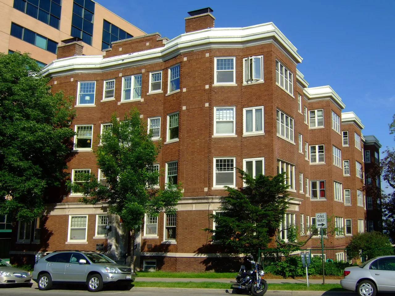 Bellevue brick apartment building in Madison with projecting window bays and trees along the sidewalk