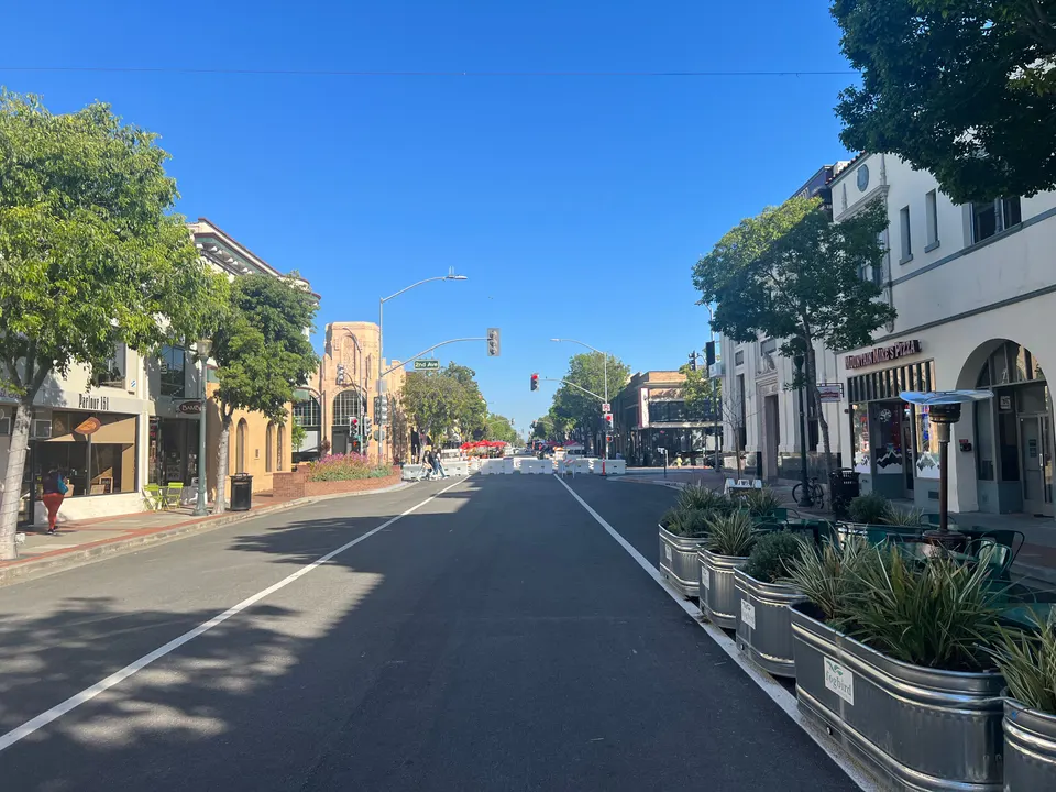 Downtown B Street in San Mateo, California, closed to traffic, with planters, street trees and two-story storefronts under a clear sky