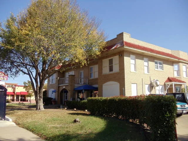 Street-facing brick facade and windows of the historic Claremont Apartments in Dallas
