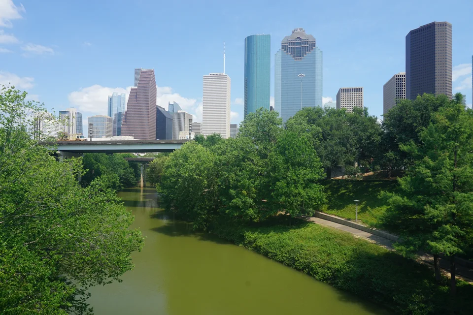 Houston skyline beyond the trees and water of Buffalo Bayou Park